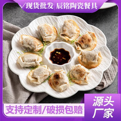 白い陶磁器の餃子の皿は酢の皿を持っています。