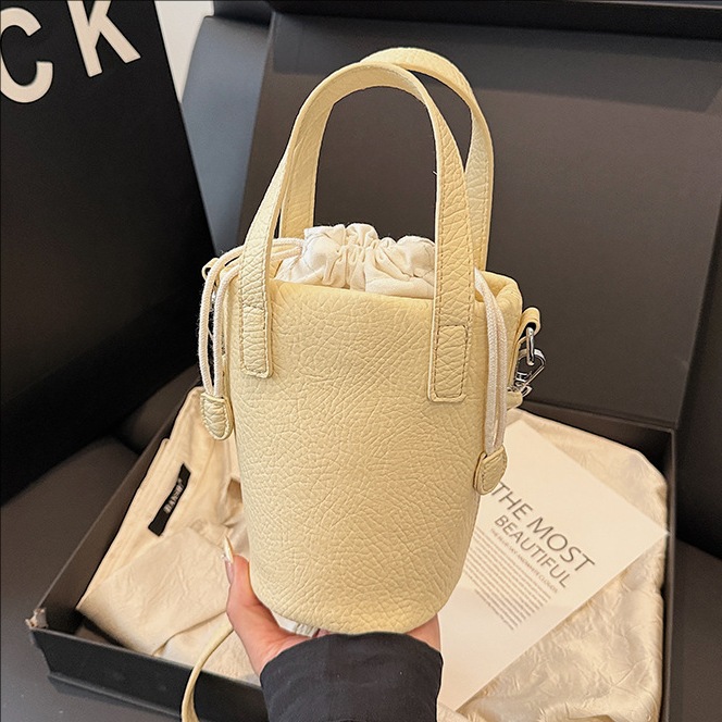 Bolso de cubo de cuero de cera de aceite retro con patrón de lichi transfronterizo para mujer 2025 nuevo bolso de mensajero de un solo hombro de diseño de nicho de alta gama