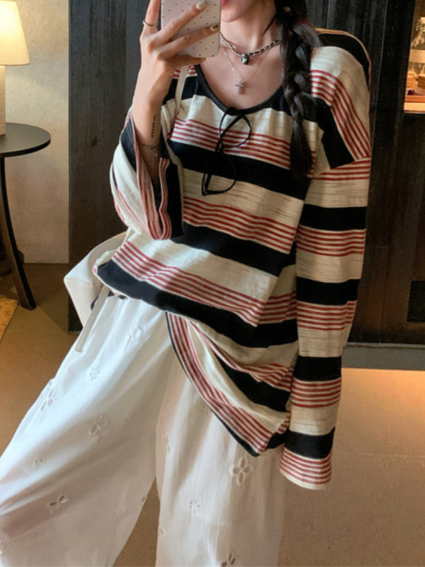 早秋のゆったりとした色のストライプの肌理感の長袖の日焼け止めはやせているニットの女性の怠惰な風のカジュアルな上着の外掛けを現します。|undefined