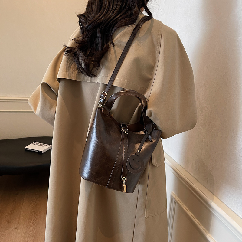 Bolso retro versátil para mujeres 2024 moda nuevo bolso de cubo de mano alta textura de transporte aéreo bolso de mochila