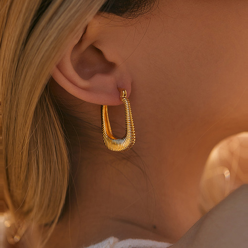 Elegant, heavyweight-inspired ear clips with a textured, premium feel—featuring a retro-style oval copper tube design plated in 18K real gold and boasting a distinct granular texture.