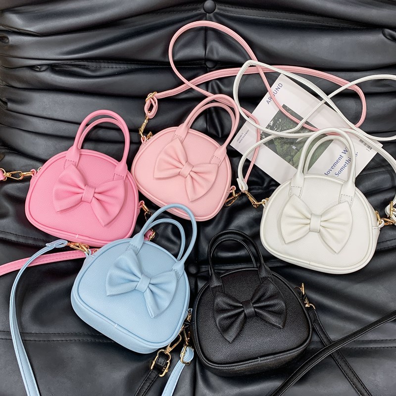 2025 nuevo bolso para niños bolso de niña con lazo dulce y lindo bolso de mensajero para bebé de color sólido simple
