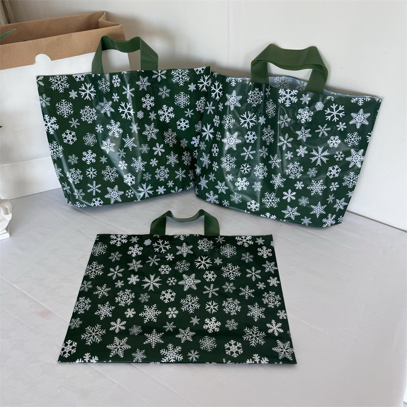クリスマスの祝日の緑の厚いプラスチックの贈り物の服の店は手提げの袋の包装で厚いショッピングを包装して祝い事を包装します。|undefined