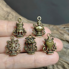 複数のチベット式の小さい器の要素はペンダントの小さい仏の札を飾って手の串のネックレスのクリップの仕切りのアクセサリーの部品を見ます。