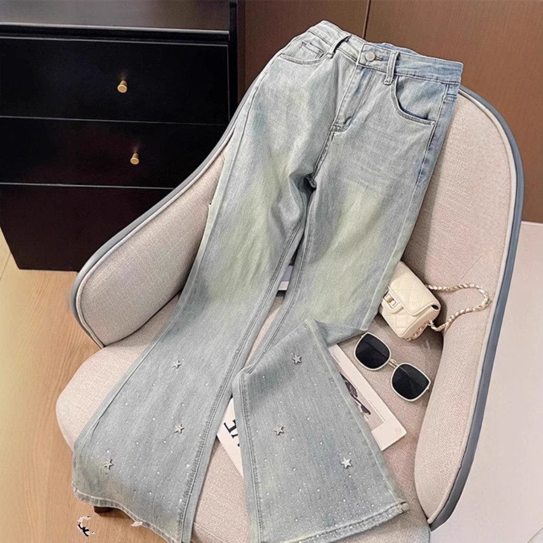 Calça jeans feminina de cintura alta com detalhes em estrelas e strass, modelagem flare, visual que afina a silhueta e favorece mulheres de estatura baixa. Jeans feminino da moda para a primavera._voghion.com
