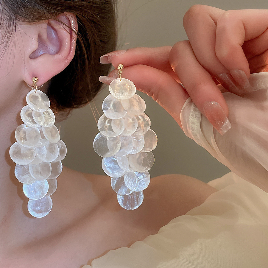 Pendientes de borla de concha blanca redonda con aguja de plata Pendientes de todo fósforo de moda de estilo de vacaciones Pendientes de alta gama de nicho al por mayor