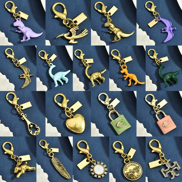 Multiple Styles of Gold Alloy Keychains with Dinosaur, Four-Leaf Clover, and Heart-Shaped Pendants, Lobster Clasp Accessories, and Exquisite Ornaments