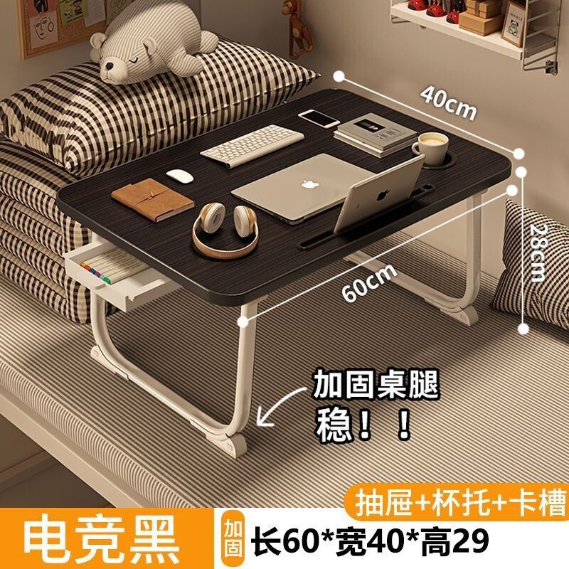 ベッドの上の小さい机のノートパソコンの机の上で折り畳みます。|undefined