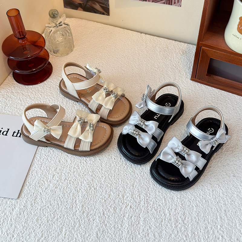 Sandálias de niñas 2026 verano nuevo estilo coreano arco para niñas zapatos de playa de dedos desnudos estudiantes zapatos de princesa