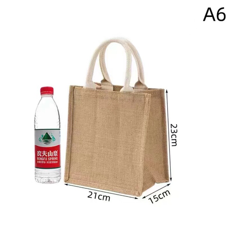 現物の麻の袋と同じ黄麻のショッピングバッグのプレゼントのレトロな亜麻の手提げ袋の空白の手描きの麻の布のカバンは注文します。|undefined