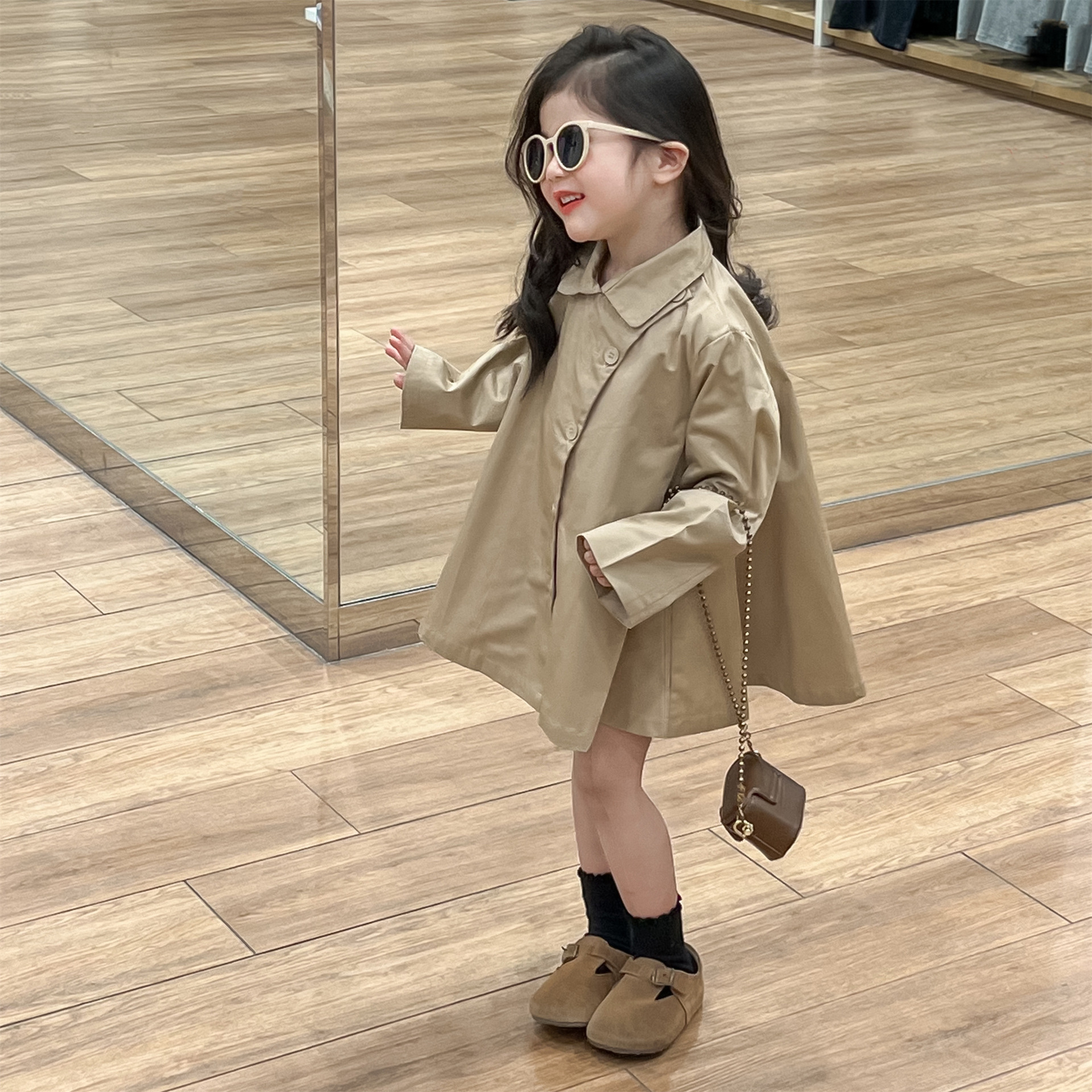 Korean children's spring 2024 dress for girls with a relaxed hem, slanted lapel, and a medium-length, khaki-style coat.