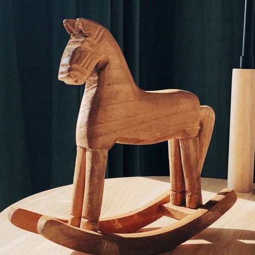 Hand-carved wooden horse from natural wood, pine wood rocking horse with a nostalgic and retro country-style American rural decoration, a rocking horse