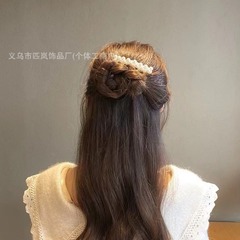 後頭部砕毛櫛ヘアカードdiy手作りの髪飾りの女性が逆に櫛の髪を挟んで額の前髪を整理して神器の髪を整えます。