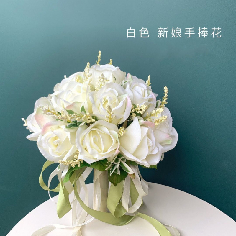 手に花を持つ新婦の韓国式結婚式の領収書のシミュレーションの花束の森系のウェディングドレスの撮影の道具の手に花をささげます。|undefined
