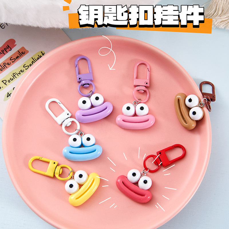 かわいいアニメの大きな口のキーホルダーは学生のカバンを飾っています。