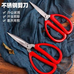 ステンレスのオフィス用はさみの赤いプラスチックの柄は布地の糸くずを切ります。