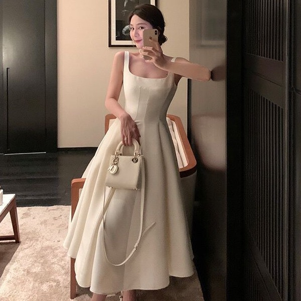 A simple French-style satin Hepburn-inspired white dress for weddings, perfect for registration or outings, with a fitted waist and spaghetti straps.
