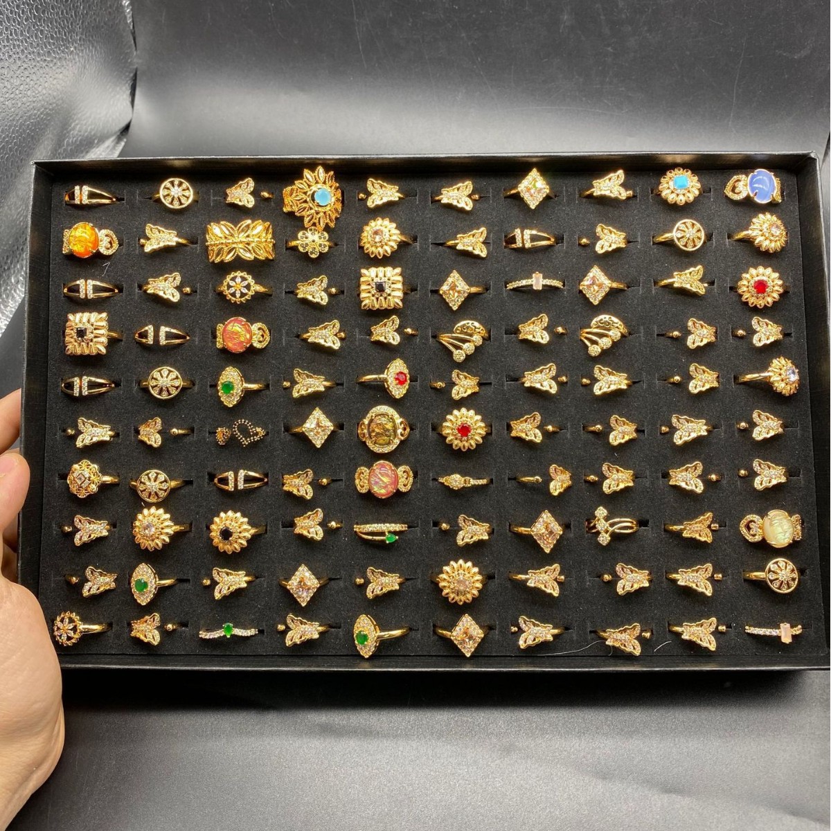 Una caja de 100 estilos aleatorios con anillos de nicho transfronterizo diseño de moda anillo de zircón chapado en oro al por mayor