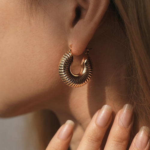 Elegant, heavyweight-inspired ear clips with a textured, premium feel—featuring a retro-style oval copper tube design plated in 18K real gold and boasting a distinct granular texture.