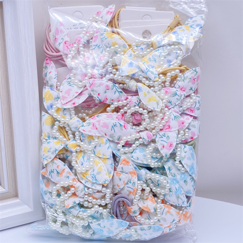 Etiqueta de estilo coreano accesorios para el cabello para niños Perla pequeña pajarita cuerda de pelo chica estudiante cabeza cuerda banda de goma dos yuanes suministro de la tienda