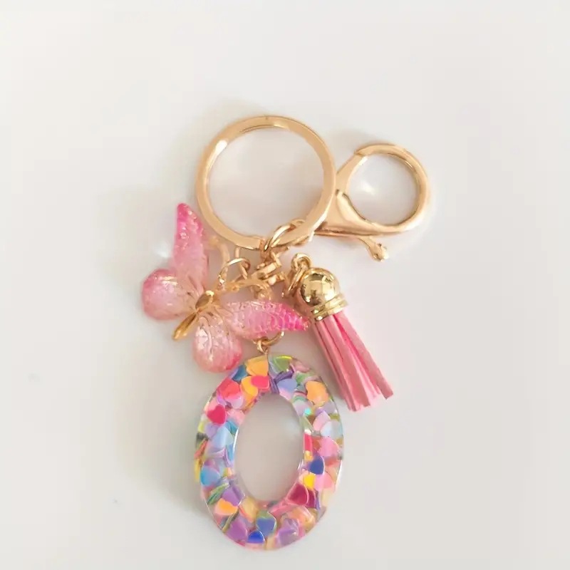 2024 transfronteriza en stock resina rosa con lentejuelas 26 letras inglesas llavero colgante mariposa borla Accesorios