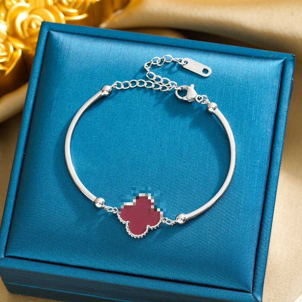 Pulsera de trébol de acero titanium vendedora caliente transfronteriza europea y americana con incrustaciones de concha pulsera colgante pulsera de diseño avanzado sin desvanecimiento al por mayor