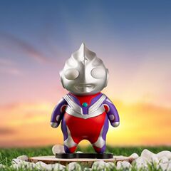Q版ディガの太ったウルトラマンの手はおもちゃのネットの赤いかわいい模型のデスクトップの車の上で部品の男子学生の日のプレゼントを並べます。