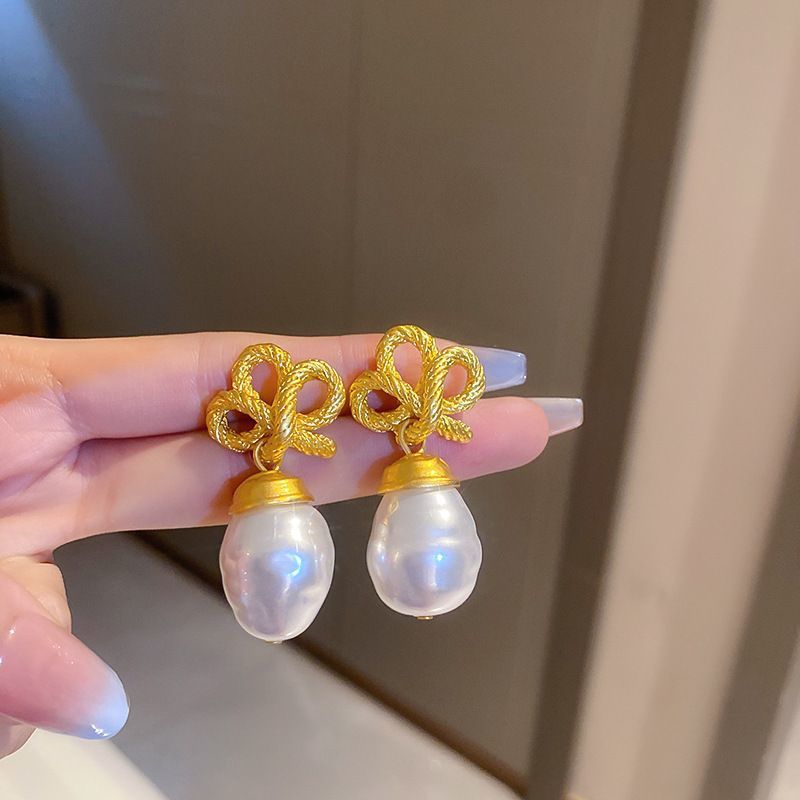 Pendientes de amor de perlas de lujo ligero con aguja de plata Pendientes de sentido de alta gama de temperamento de nicho Pendientes de estilo de palacio de todo fósforo de moda al por mayor