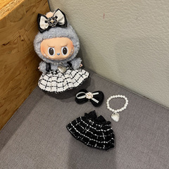 Labubuはパーティーの子供服に座っています。