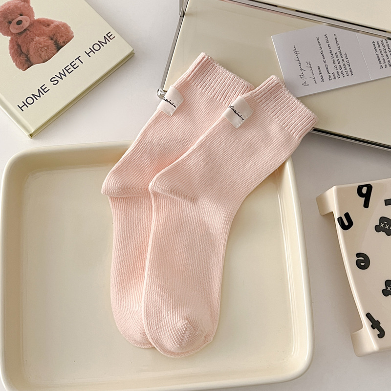 Otoño e invierno Nuevos calcetines de algodón absorbentes de sudor calcetines de pila serie de crema para mujer estilo ins Corea del Sur etiqueta de tela calcetines de media pantorrilla moda