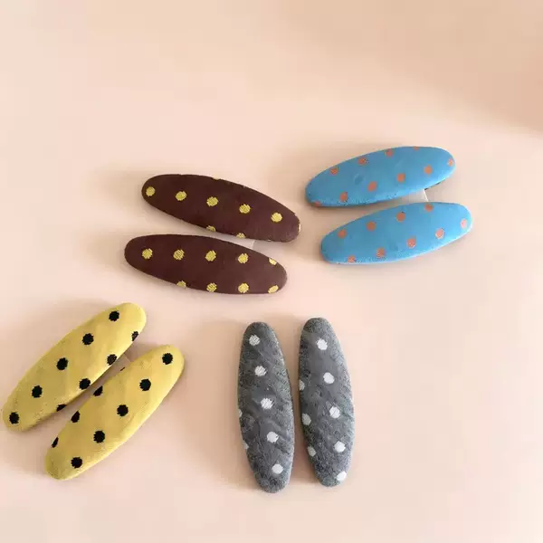 Retro polka dot oval-shaped hair clips for women, featuring a simple fabric design, perfect for securing side bangs and adding a fresh, versatile touch to your hairstyle