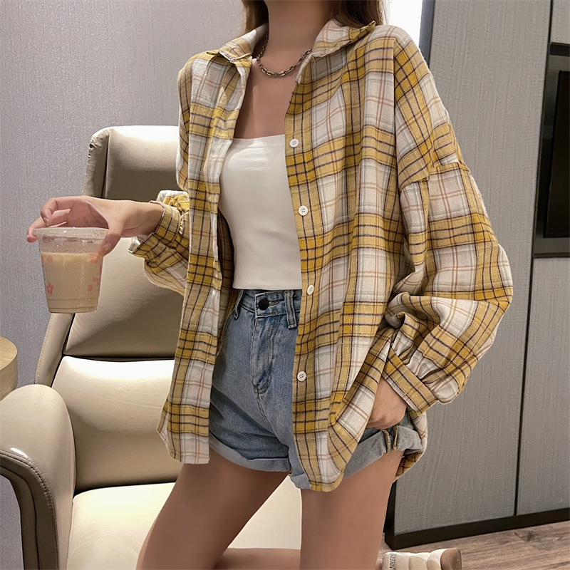 実際に日韓のレトロな格子のシャツの女性の外で長袖のシャツのコートの上着のゆったりしている設計感の長袖のコートをたたきます。