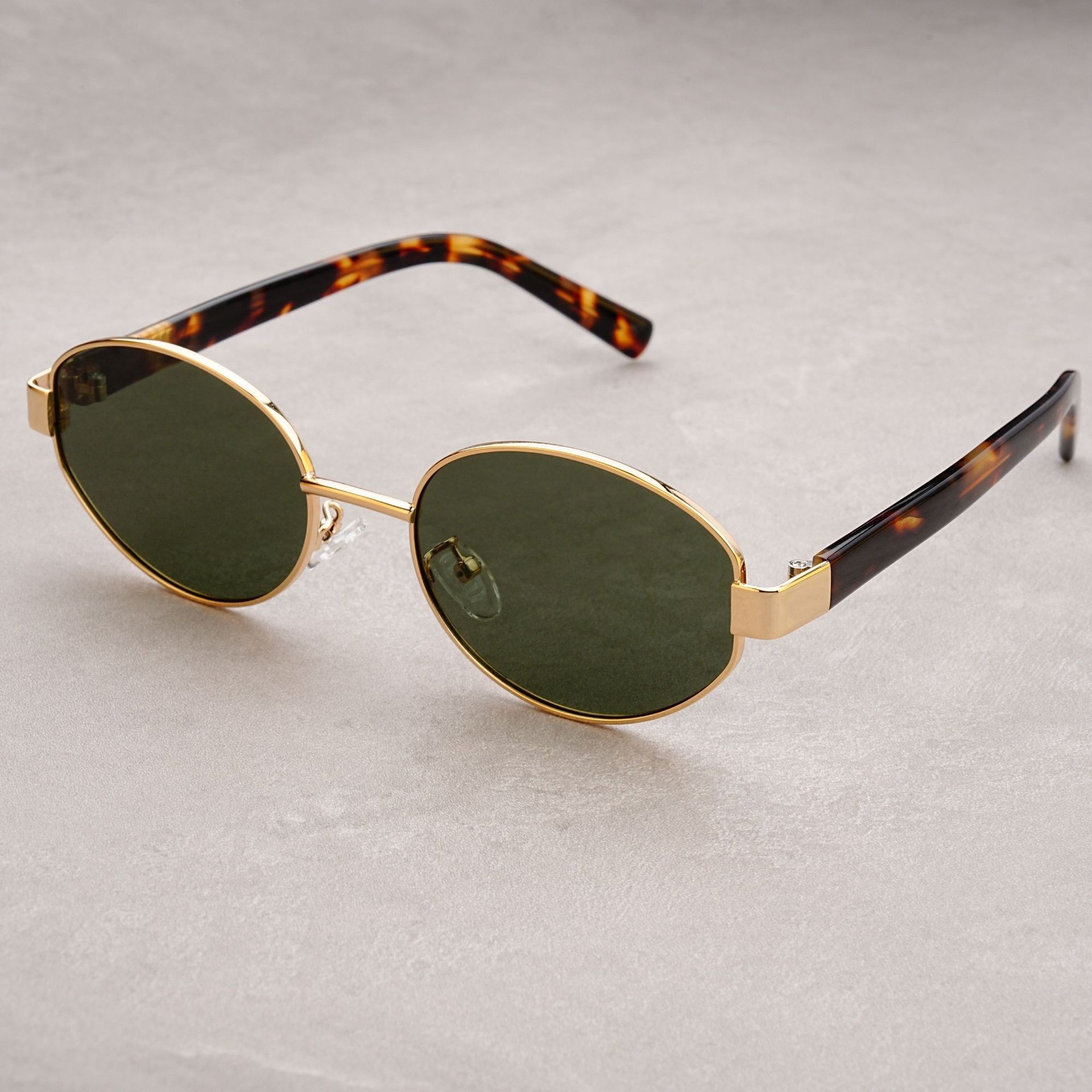 Vintage-Sonnenbrille im Retro-Stil mit strukturierter Oberfläche, dicken, ovalen, polarisierten Gläsern und UV-Schutz durch Acetat-Einsätze an den Bügeln._voghion.com