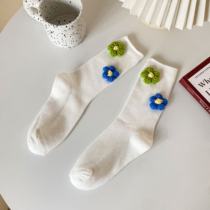 흰색 배경에 작은 파란색과 녹색 꽃