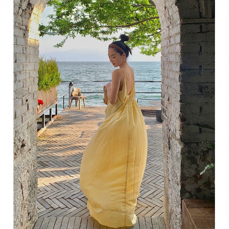 三亚黄色吊带连衣裙宽松慵懒风露背性感沙滩裙女夏季海边度假长裙