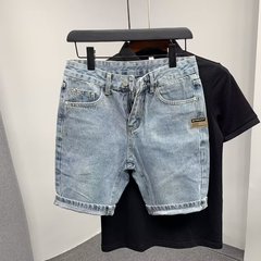 街頭のハンサムな水洗いは古いデニムの半ズボンをします。
