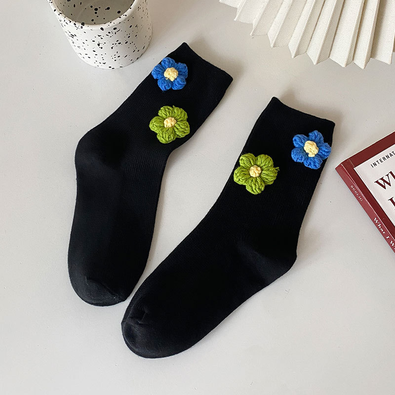 검은 배경에 작은 파란색과 녹색 꽃