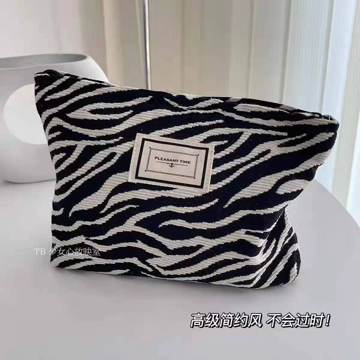 Versión coreana de la bolsa de cosméticos con patrón de cebra, portátil de gran capacidad, bolso de mano con sentido avanzado, bolso de almacenamiento de lavado de viaje, damas