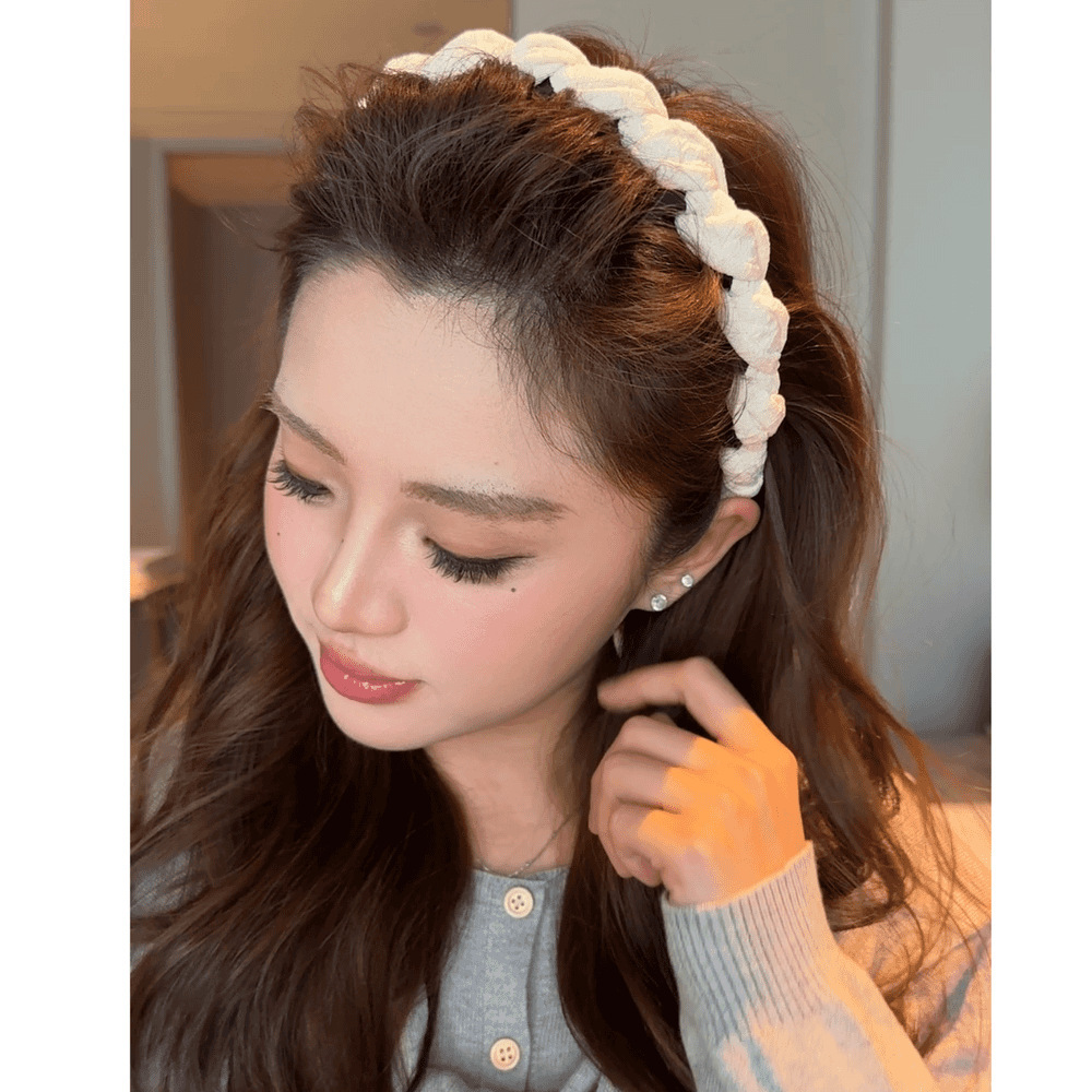 A beige twisted tooth comb headband