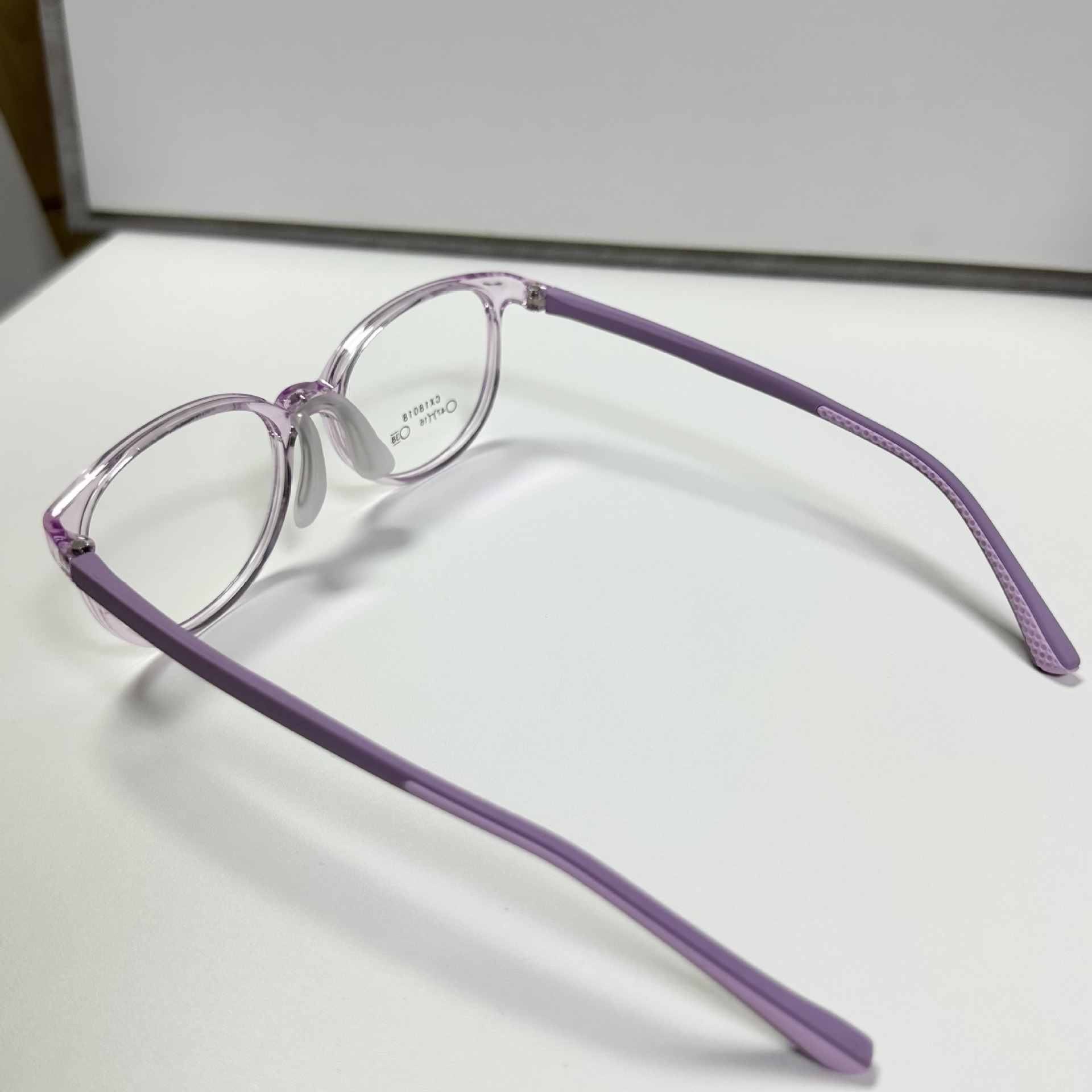 Montura de gafas infantiles translúcidas de color morado con almohadillas nasales de silicona ajustables, se pueden adaptar con lentes graduadas, venta al por mayor desde Danyang.