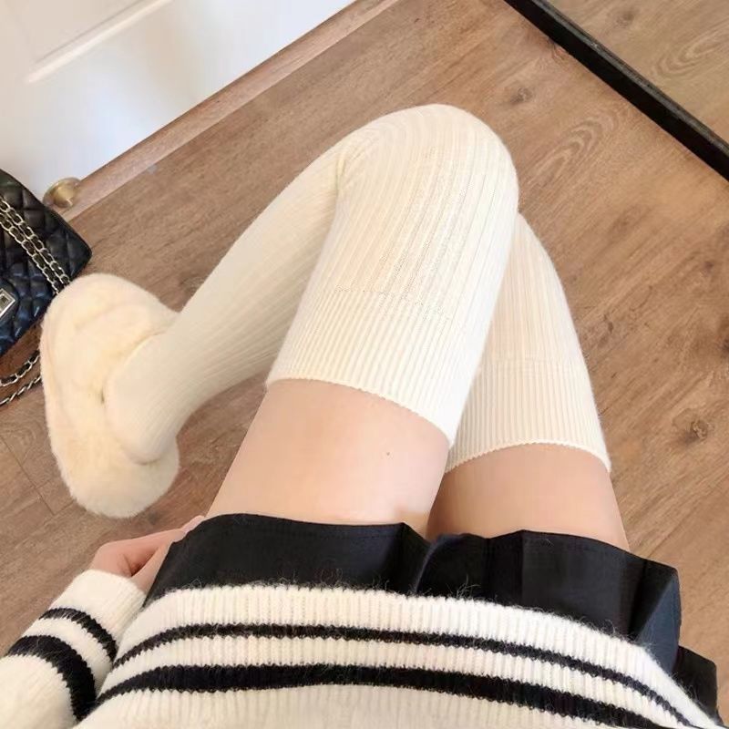 太ももの靴下が膝を越えているストッキングの女性は、純綿を厚くして長くしている高筒靴下が痩せている縦縞の保温膝保護靴下を見せている|undefined
