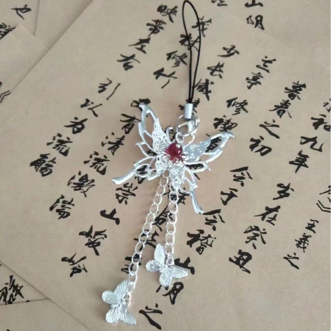 One hand holding an umbrella and the other holding his silver plate mobile phone chain pendant butterfly key chain hanging chain goo this chain red beads silver plate chain