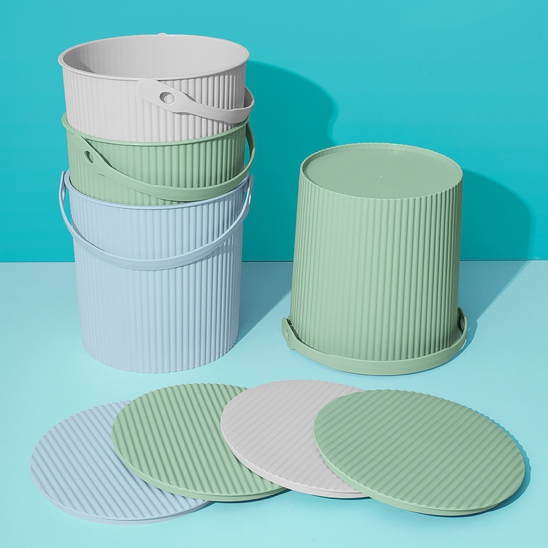 メーカーは家庭用の手提げ蓋付きのプラスチック製の桶を提供しています。|undefined