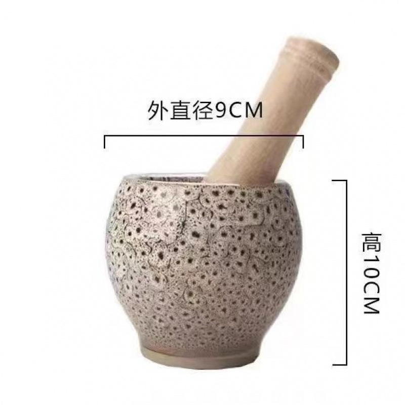 旧式の石臼でにんにくのハンマーをいじっています。|undefined