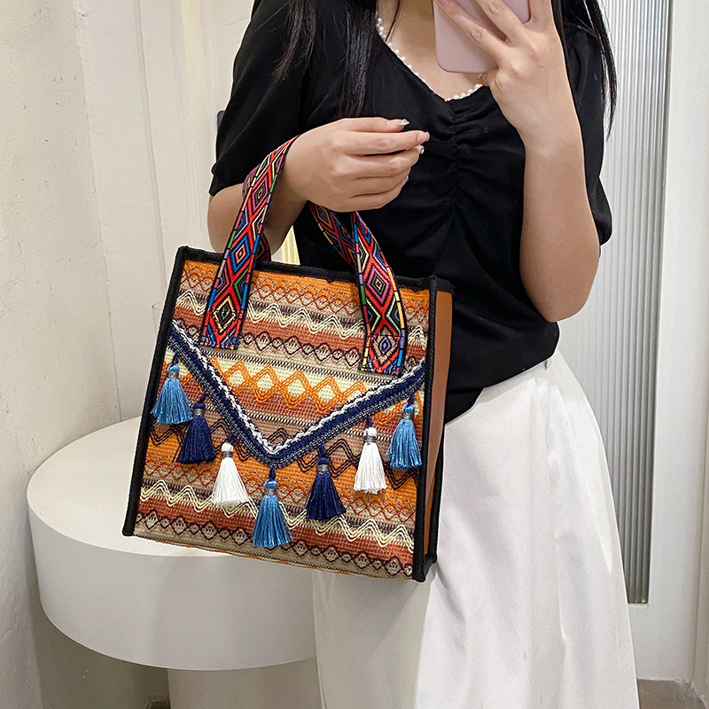 New hand-held fringed shopping bag 2022, fashionable ethnic style, Hong Kong style bucket bag, versatile woven bag for women Item Picture
