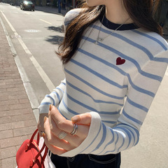色のストライプにぶつかって痩せています。ニットの底のシャツを着ています。