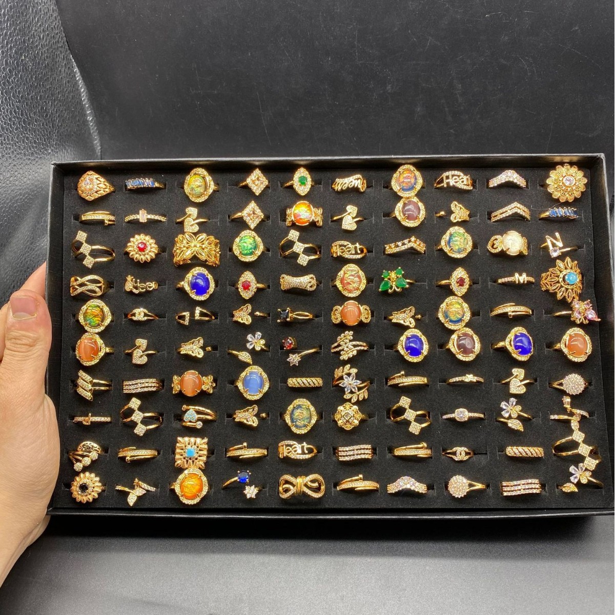 Una caja de 100 estilos aleatorios con anillos de nicho transfronterizo diseño de moda anillo de zircón chapado en oro al por mayor