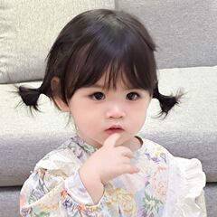 子供のかつらの女性は前髪をそろえて短い髪をします。