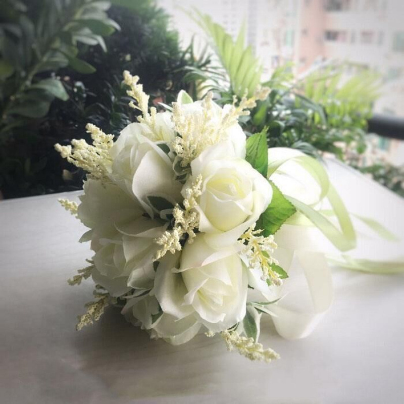手に花を持つ新婦の韓国式結婚式の領収書のシミュレーションの花束の森系のウェディングドレスの撮影の道具の手に花をささげます。|undefined