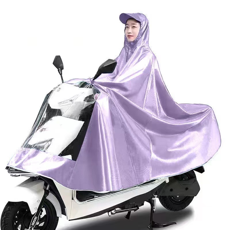 レインコート電気自動車のレインコートを大きくして、オートバイの二人のシングル男性女性が豪雨防止全身に足を隠します。|undefined